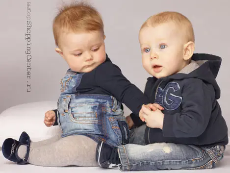 Модная одежда для малышей: на девочке – сарафан Dolce&Gabbana, на мальчике – джинсы и толстовка Dolce&Gabbana